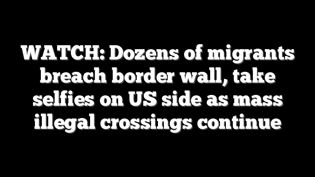 WATCH: Dozens of migrants breach border wall, take selfies on US side as mass illegal crossings continue