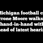 Ex-Michigan football coach Sherrone Moore walks into court hand-in-hand with wife ahead of latest hearing